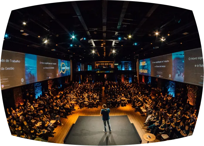 A conference audience in a darkened hall