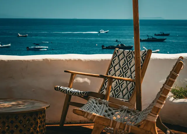 A guest with a coffee on a sunlit hotel terrace